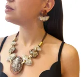 Par de aros colgantes con forma geométrica, compuestos por una pieza superior trapezoidal color ámbar y una pieza inferior semicircular color beige.