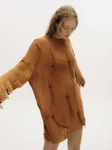 Sweater amarillo mostaza de punto calado con detalles rasgados y flecos bordados con canutillos de madera. Tiene cuello y puños bordados en crochet y pespunte bordado en hilo grueso en la sisa.