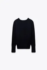 Sweater negro de punto liso con cuello redondo y mangas largas con botones dorados en los puños.