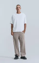 Remera blanca de algodón con corte crop, calce oversize, hombros caídos y cuello redondo.