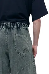 Pantalón unisex de denim 100% algodón con lavado color menta. Corte wide y relajado, tiro medio, pierna ancha y caída larga. Cintura con elásticos laterales, costuras curvas y bolsillos delanteros y traseros redondeados.