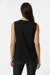 Musculosa a rayas horizontales marrones y blancas, de algodón, corte holgado y cuello redondo.