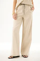 Pantalón de lino azul marino de corte recto con cintura alta y cordón ajustable. Presenta costuras en contraste color blanco.