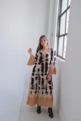 Vestido midi con estampado tie-dye en tonos negro, beige y marrón. Tiene corte holgado, mangas 3/4 acampanadas y falda con volantes.