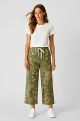 Pantalón capri blanco con estampado floral azul, de algodón y calce holgado.
