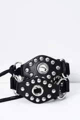 Cinto de cuero sintético negro con múltiples tiras horizontales y argollas metálicas.