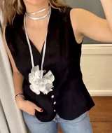 Accesorio plateado de cuero que se puede usar como colgante, faja o gargantilla. Presenta un dije grande en forma de flor con pétalos de tul.