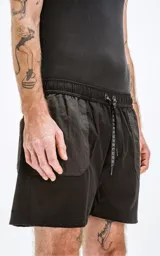 Short de baño negro con bolsillos laterales y traseros, cintura elástica con cordón ajustable.