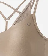 Top deportivo color tostado, confeccionado en microfibra con efecto satinado. Presenta copas y correas dobles ajustables.