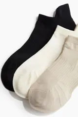 Pack de tres pares de medias deportivas cortas, confeccionadas en tejido funcional DryMove™ que absorbe la humedad. Incluye un par color beige, un par color crema y un par color negro.