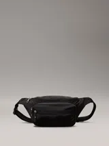 Riñonera negra con logotipo de Calvin Klein, exterior acolchado y correa ajustable.
