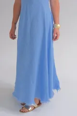 Vestido largo celeste sin mangas, confeccionado en lino italiano, con escote en V y ruedo desflecado.