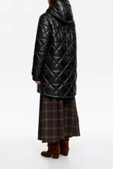 Abrigo largo de corte recto en tejido técnico negro con diseño acolchado de rombos. Presenta capucha integrada con cordones de ajuste, cierre frontal de cremallera, bolsillos laterales de vivo y mangas largas con puños elásticos. El bajo cuenta con elástico y stoppers interiores para un ajuste personalizado.