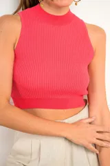 Top halter tejido color coral, con cuello alto y diseño ajustado al cuerpo.