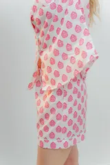 Conjunto de pijama de algodón a rayas verticales rosas y blancas, con detalles en celeste. Incluye camisa de manga corta con botones y bolsillo en el pecho, y shorts con cintura elástica.