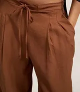 Pantalón de vestir ancho (wide leg) color marrón, con cintura elástica ajustable con lazo y pliegues delanteros.