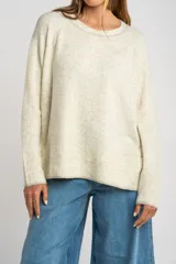 Sweater color marrón claro de tejido de punto, con cuello redondo y mangas largas.