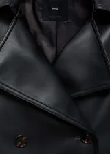 Chaqueta negra efecto piel con cuello de solapa, cierre cruzado con doble botonadura, corte crop y diseño oversize.