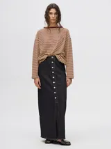 Falda midi de denim negro con hilado a la vista en el ruedo y abotonadura frontal.