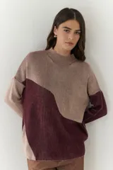 Buzo de punto con diseño geométrico en bloques de color gris y negro, de cuello redondo y mangas largas.