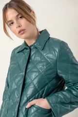 Campera de cuero negra con diseño matelassé de rombos, cuello camisero, cierre frontal con botones a presión, dos bolsillos delanteros y puños con botón.