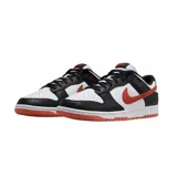 Zapatilla de corte bajo Nike Dunk Low Retro, con base blanca y superposiciones de cuero negro. Presenta el logo Swoosh y detalles en color naranja quemado (burnt orange) en el lateral, talón y suela exterior.