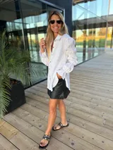 Camisa color verde lima confeccionada en lino, de corte holgado, con cuello camisero, mangas largas abullonadas con puños elásticos y cierre frontal con botones.