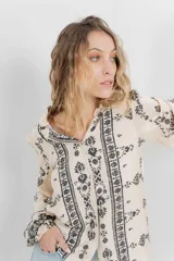 Camisa beige con estampado boho en negro, corte relajado, mangas largas con puño elástico y botones frontales.
