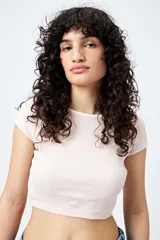 Top corto de punto acanalado color rosa, con silueta ajustada, escote redondo y ribetes blancos en cuello y mangas.