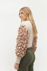 Remera negra de punto con mangas largas abullonadas con volantes.