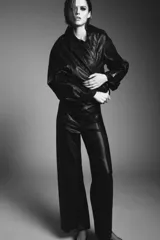 Pantalón de tiro alto color marrón oscuro con efecto piel, pierna ancha y costura marcada en el delantero. Incluye bolsillos de plastrón en la espalda y cierre frontal con cremallera, botón y gancho metálico.