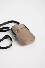 Bandolera porta celular color beige con correa larga negra ajustable.