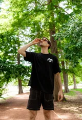 Remera negra de algodón con estampa en el pecho de dos manos formando un corazón.