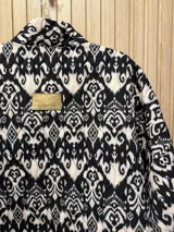 Chaqueta acolchada con estampado ikat en tonos beige y marrón, de corte holgado y mangas largas.