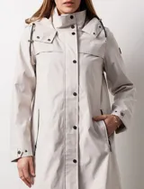 Gabardina impermeable negra, marca Weatherproof, con cierre central oculto y botones a presión. Tiene bolsillos delanteros con cierre, capucha no desmontable y forro interno de abrigo desmontable.