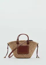 Bolso tipo canasta de paja con doble asa de mano y asa larga bandolera desmontable. Presenta un bolsillo exterior, cierre regulable y forro interior.
