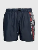 Short de baño azul marino con cintura elástica ajustable con cordón. Estampado vertical con el logo de Tommy Hilfiger en blanco y rojo en la pierna derecha.