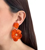 Aros colgantes con forma de flor hechos en resina color naranja.