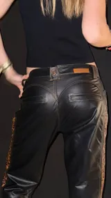 Pantalón de cuero negro con tiro medio, corte ajustado y paneles laterales con estampado animal print.