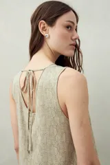 Vestido largo color beige con estampado abstracto, sin mangas y con cuello redondo.