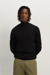 Jersey negro de punto fino con cuello alto y manga larga.