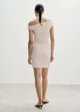 Vestido corto color beige, con escote asimétrico off-shoulder y drapeado lateral.