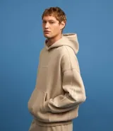 Saco beige de algodón y poliéster con capucha, bolsillo canguro, manga larga ajustada con estampa de llamas lateral, bajo ajustado y estampa lettering localizada.