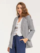 Blazer oversized de corte recto en tonos beige y rayas, con hombreras finitas y bolsillos delanteros.