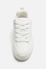 Zapatillas deportivas blancas de estilo skate con cordones gruesos y suela con plataforma.
