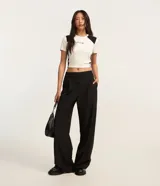 Pantalón de vestir negro, de corte recto, con trabillas en la cintura y elástico en la parte trasera.