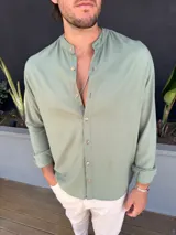Camisa verde safari de lino, con cuello mao, manga larga y corte clásico.