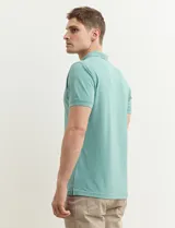 Chomba verde de piqué de algodón con cuello clásico y tapeta de dos botones. Logo bordado en el pecho.