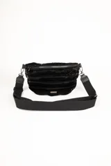 Cartera tipo riñonera capitoneada con un compartimento principal y un bolsillo interno con cierre, que aporta textura y brillo.