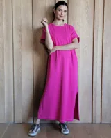 Vestido largo fucsia de corte recto y mangas cortas, con aberturas laterales y costuras a contratono.